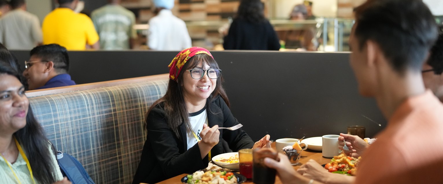 A group of students sitting in a booth enjoying a meal.