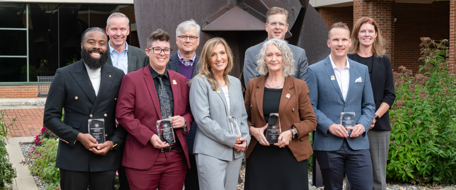 The alumni award honorees all standing with their awards