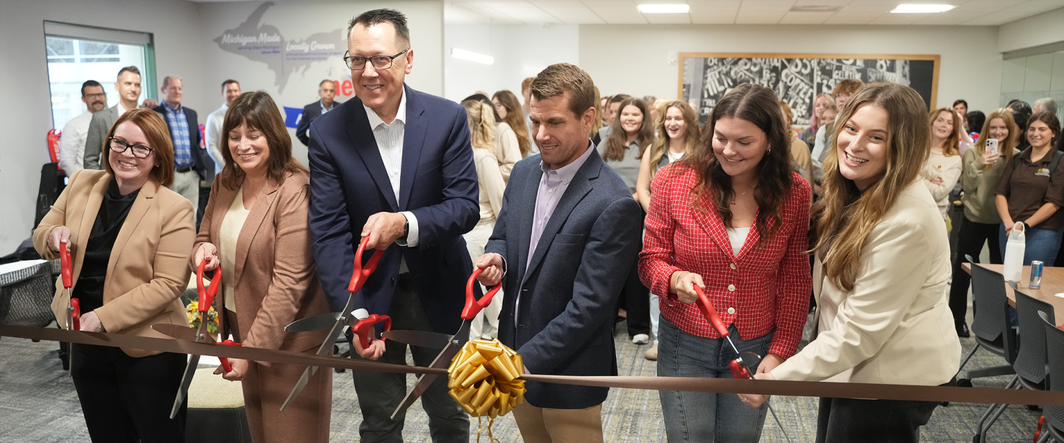 People cutting a ceremonial ribbon to celebrate a grand opening