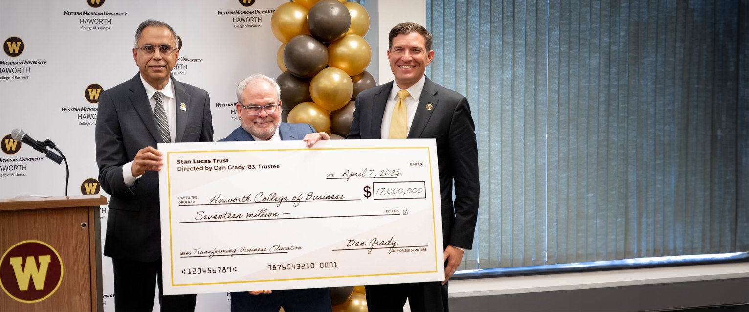 Dan Grady, Dean Deshpande, and President Kavalhuna holding a $17 million dollar check