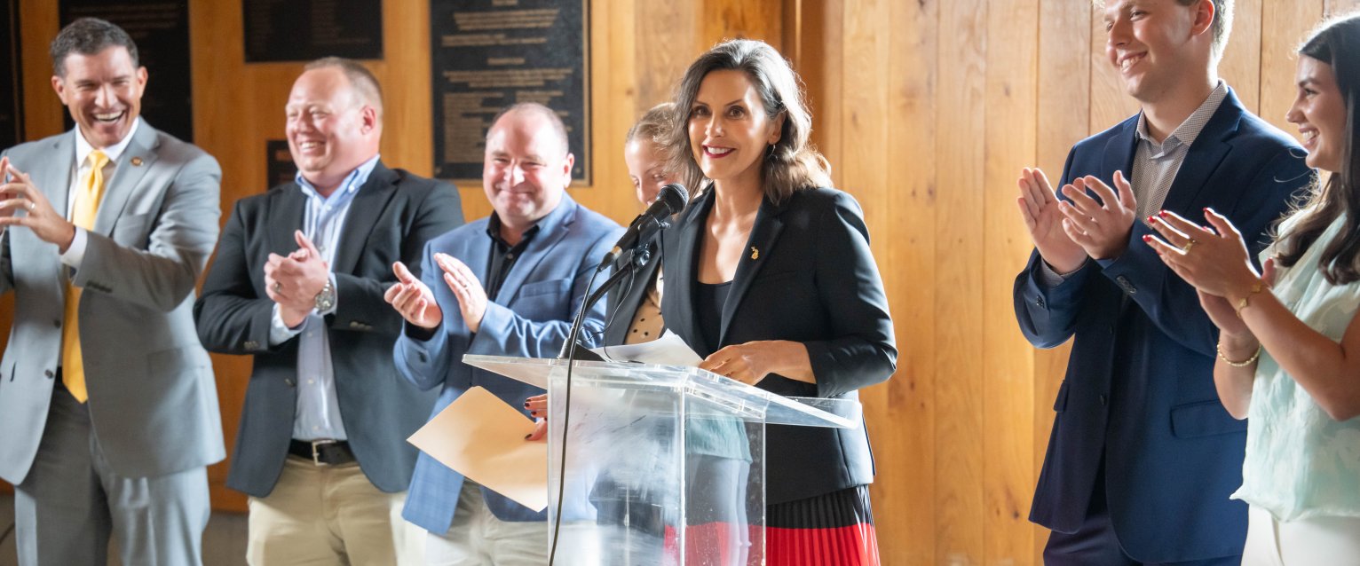Gretchen Whitmer. Governor of Michigan at a podium celebrating Sleeping Giant Capital