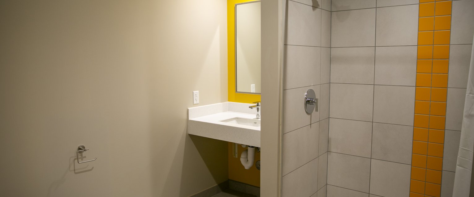 A single-occupancy bathroom featuring a toilet, a sink, and a shower.