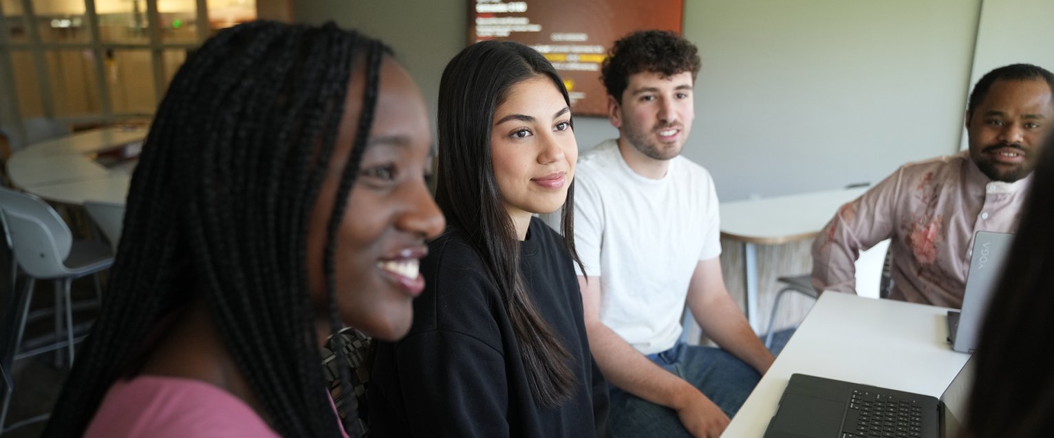 a group of five students at a table together