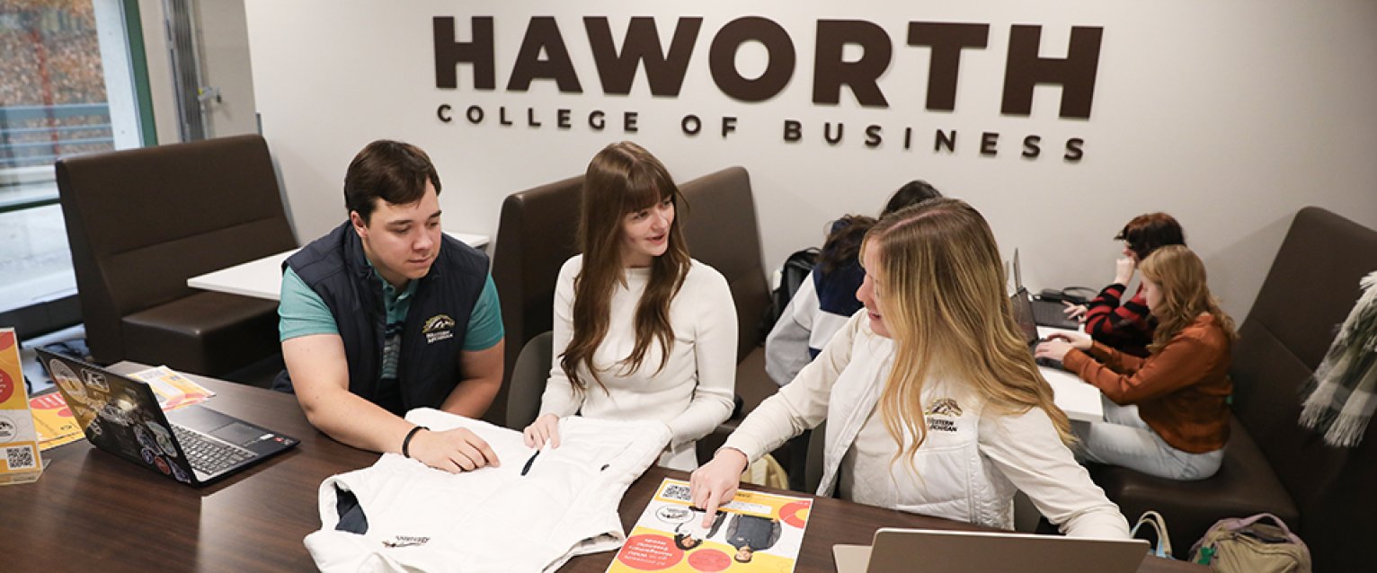 A group of students in a meeting discussing their product
