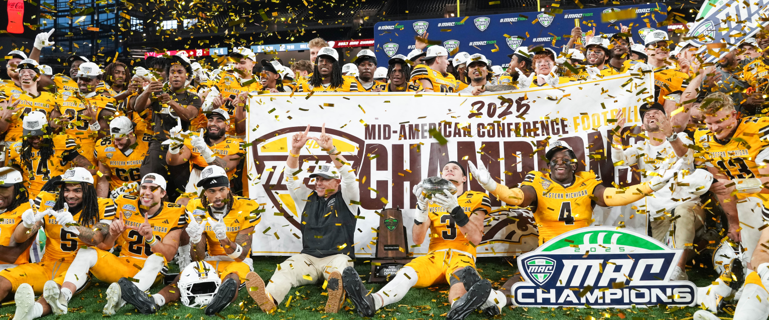 The WMU football team sits on a football field surrounded by confetti after winning the MAC championship.