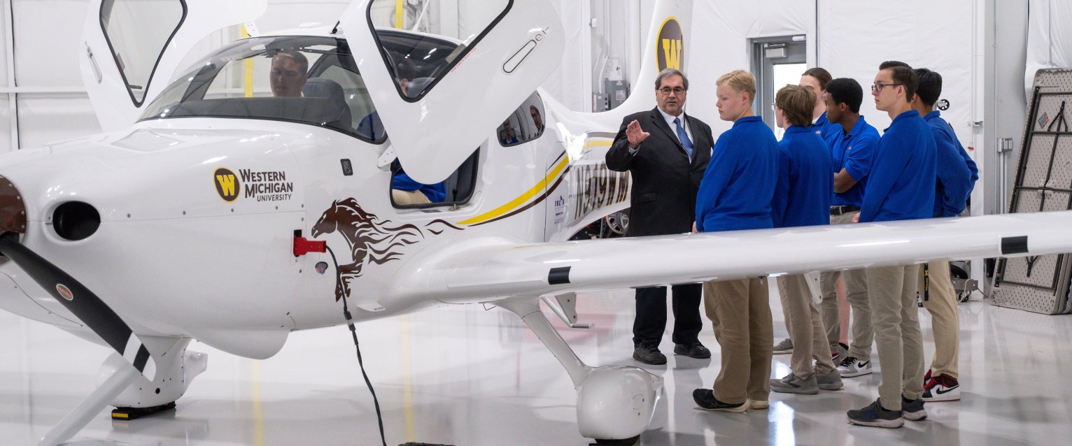 Ray Thompson, aviation college dean, shows a WMU plane to a group of high schoolers at the West Michigan Aviation Academy.