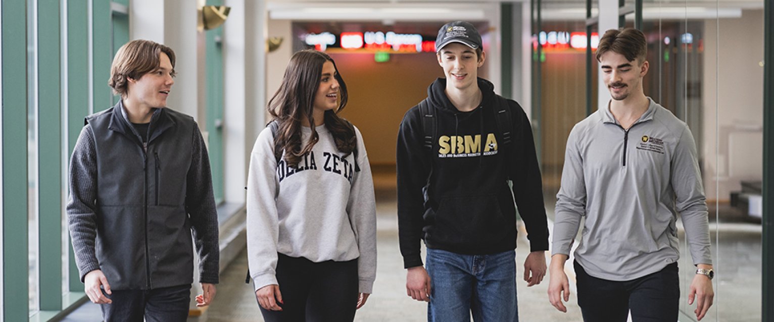 A group of sales students walking through the hallway