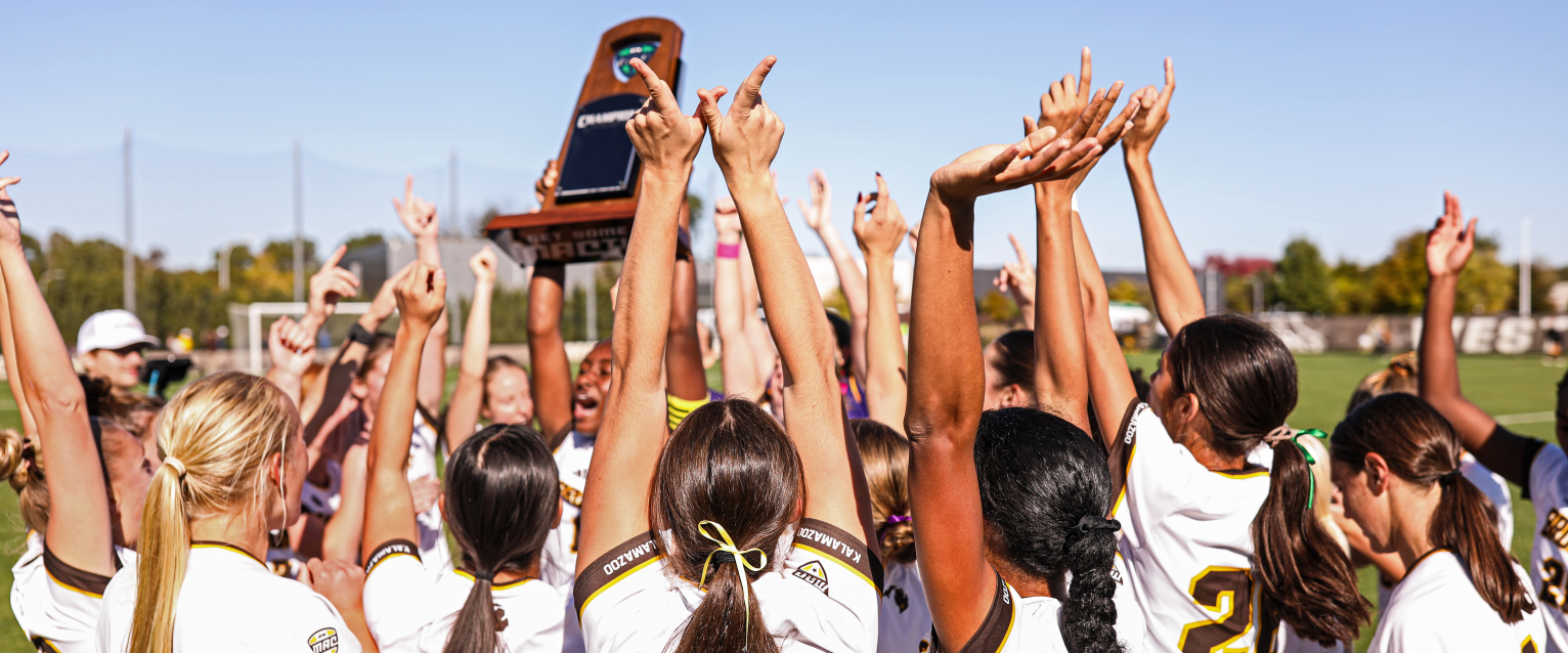 The WMU women's soccer team hoists the MAC Championship trophy into the air.