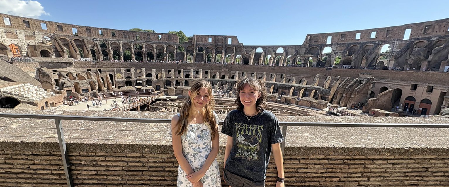 Two students standing in front of the Roman Colosseum 