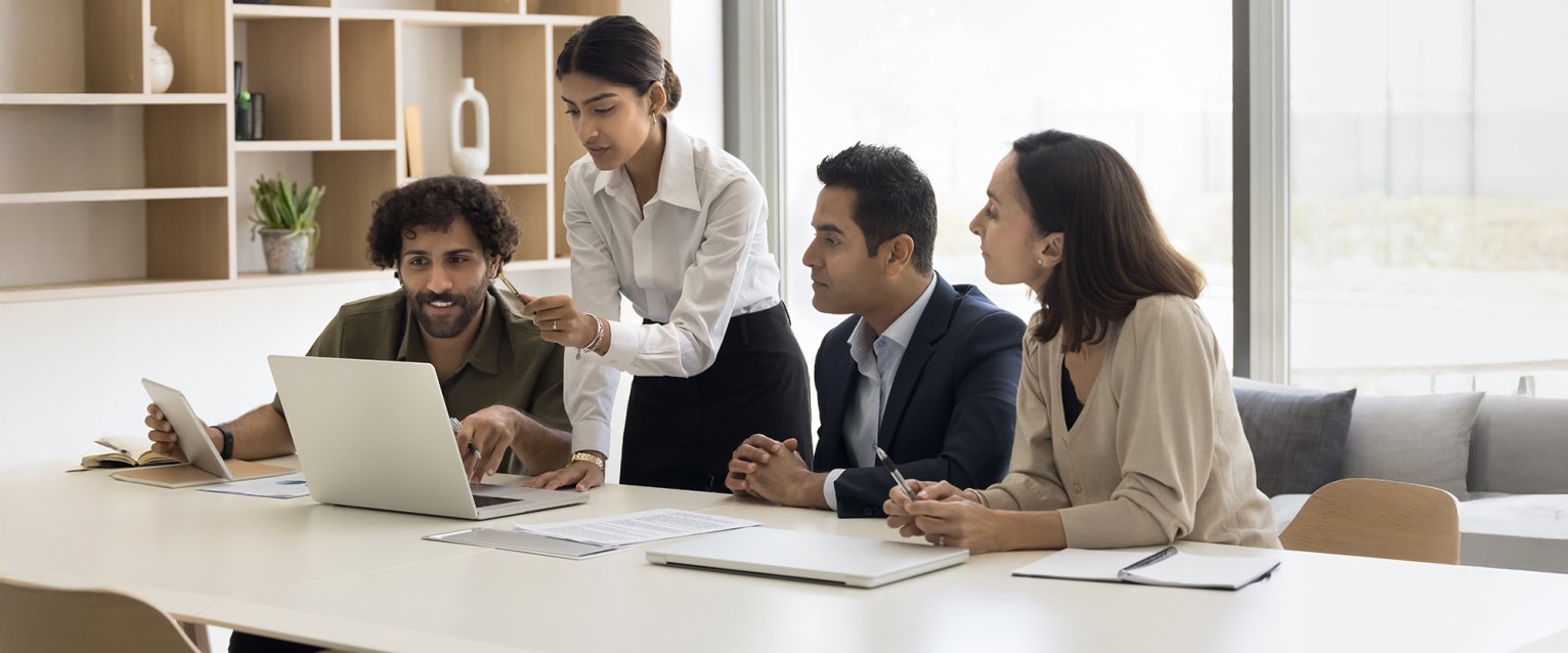 Group of business professionals at a table with a laptop