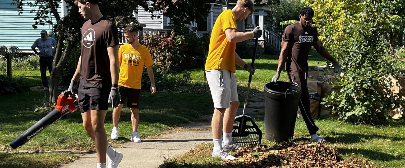 WMU Men's Basketball players, volunteering in the Vine Neighborhood, working on neighborhood cleanup with Building Blocks of Kalamazoo.
