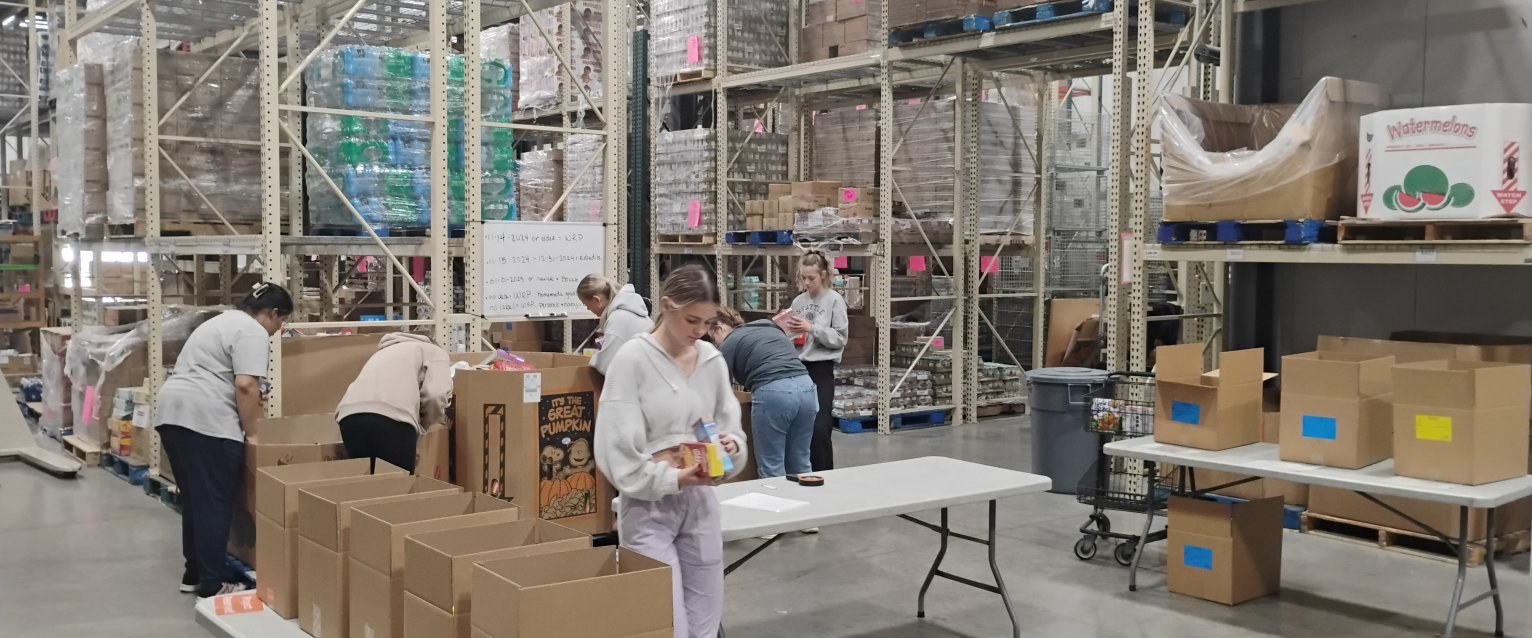 WMU student volunteers working in the warehouse at Kalamazoo Loaves and Fishes, preparing groceries for area residents.