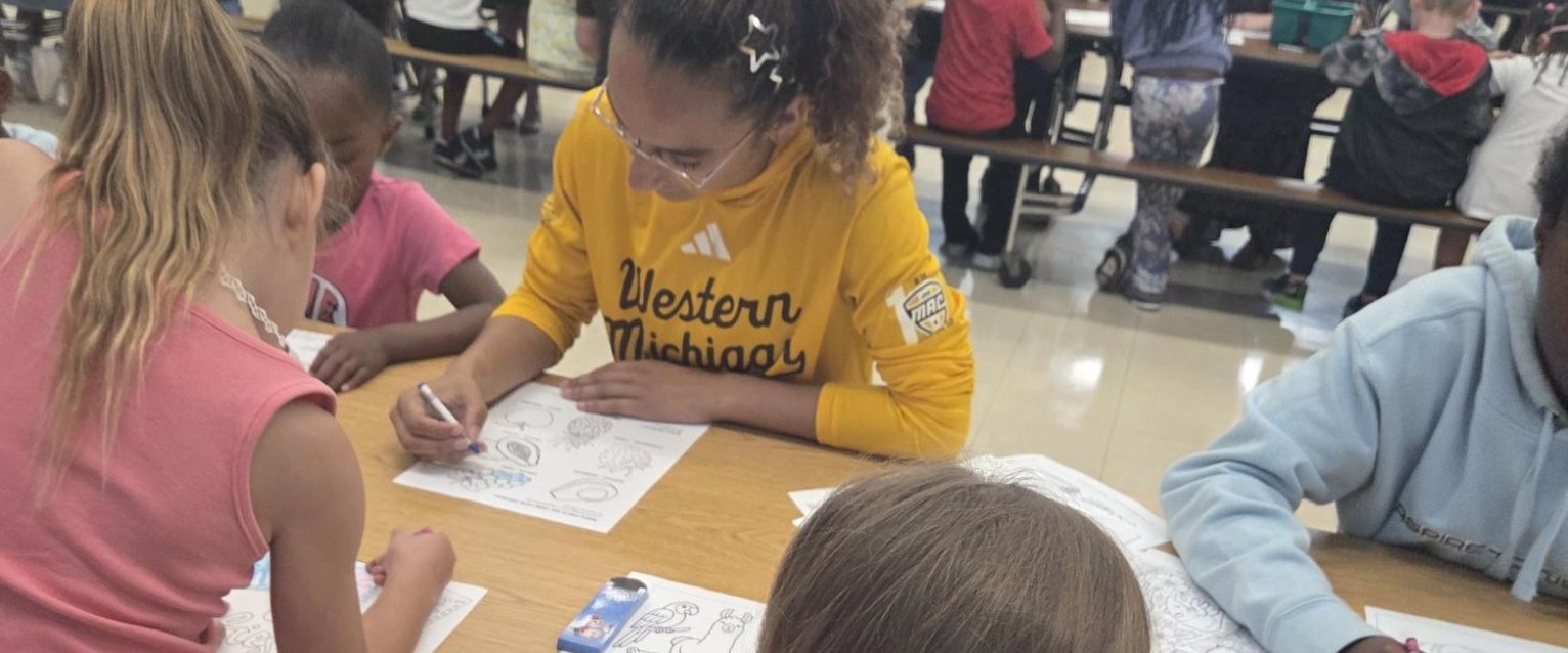 Students from Woods Lake Elementary, coloring together with WMU student volunteers..