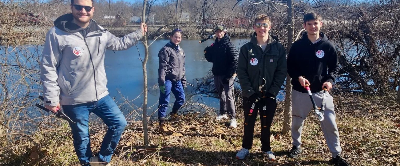 WMU student volunteers standing near a pond at Vergerg Park during the Kalamazoo river cleanup.