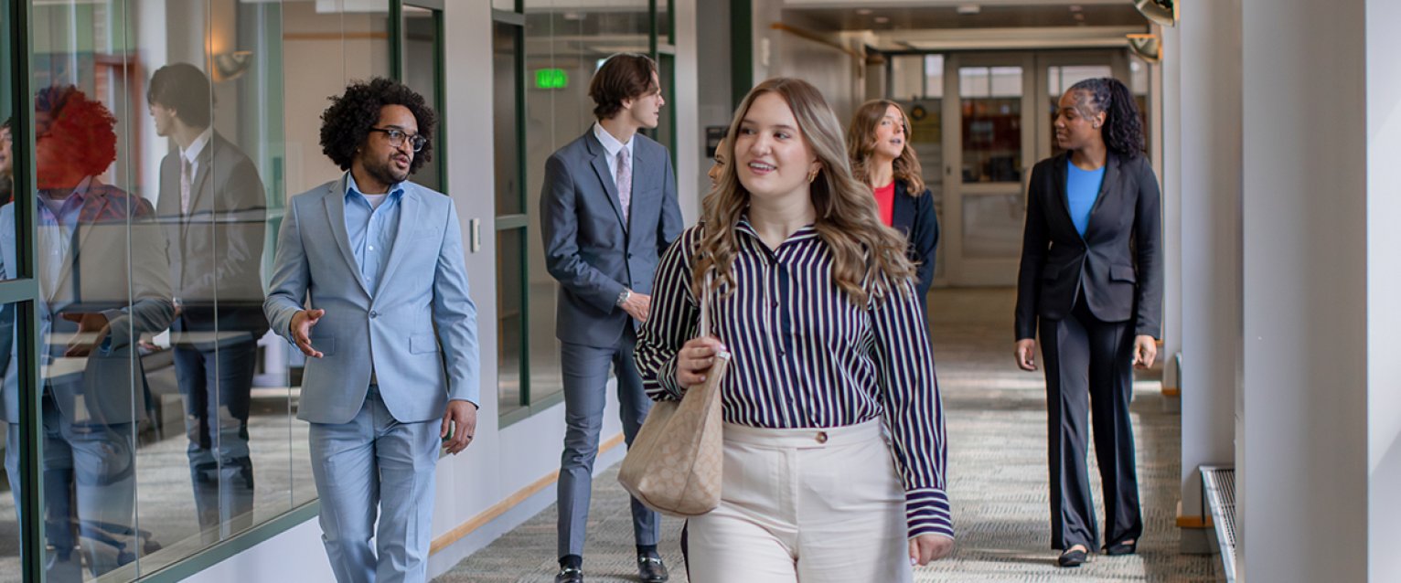 A student walking through the halls with others behind them