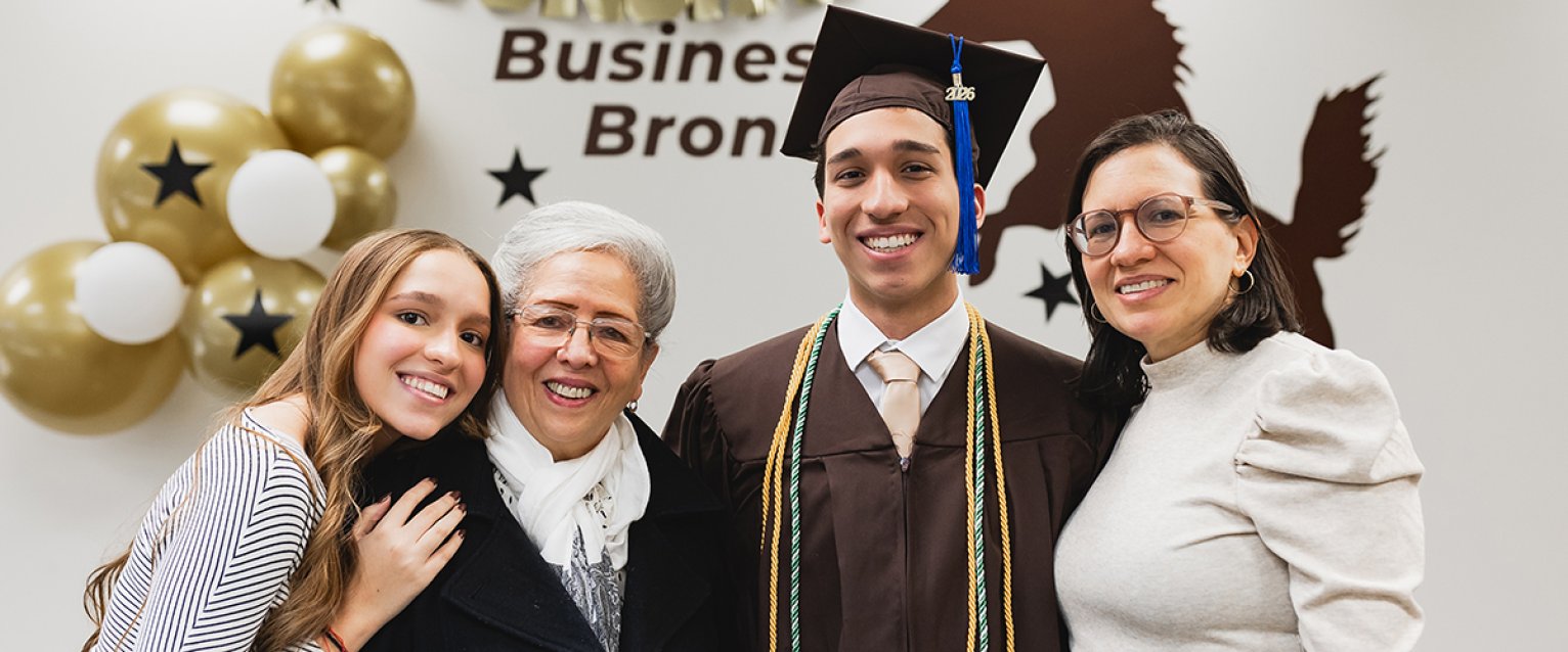 A family posing with their newly graduated bronco