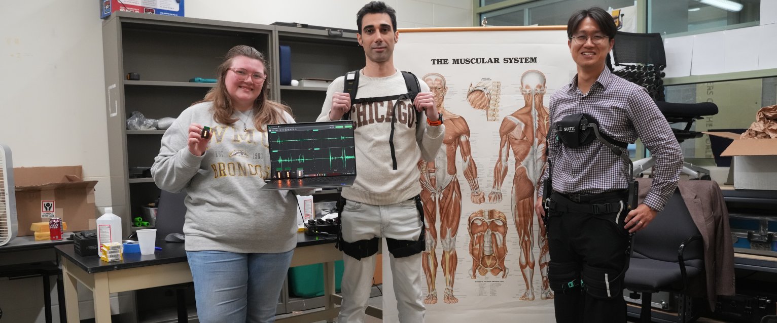A professor with two students, showing off their lab equipment. 