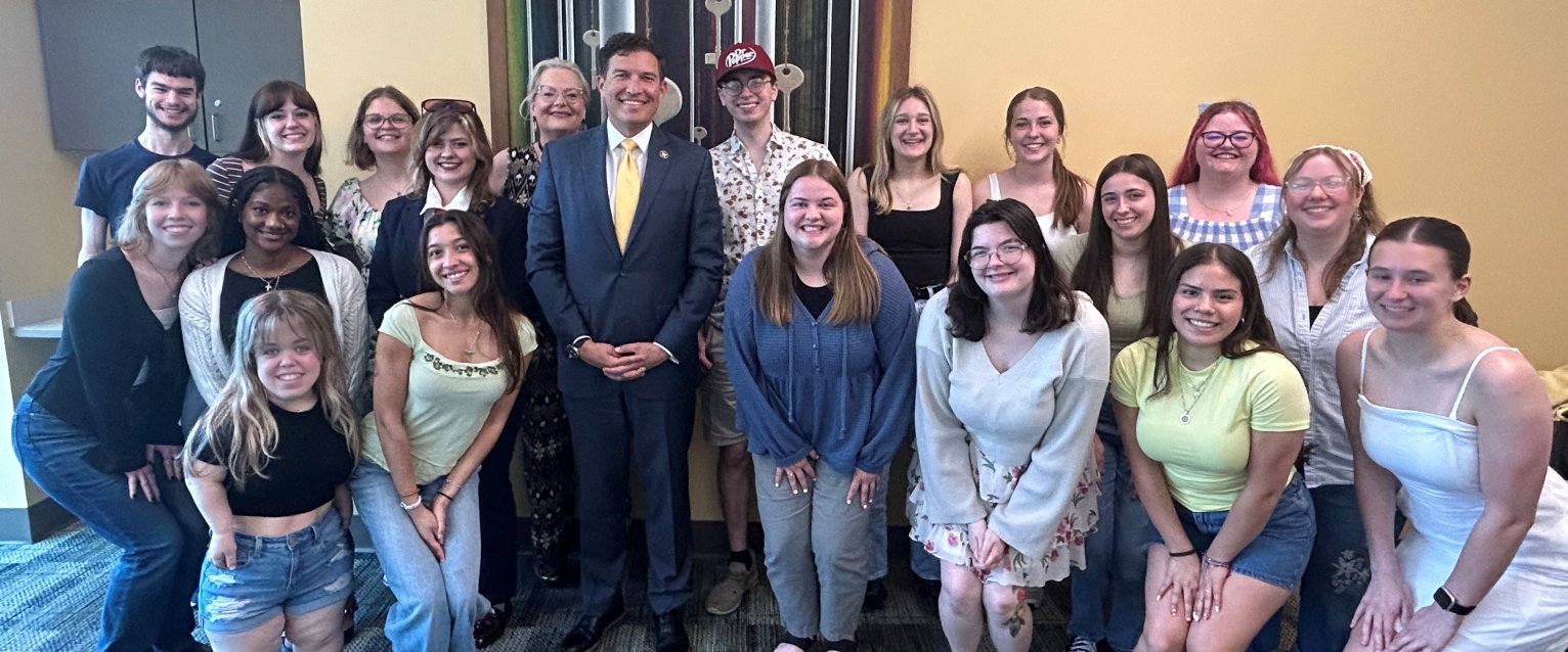 President Kavalhuna stands with Instructor Elizabeth Cowan's honors class in honors college room 1014.