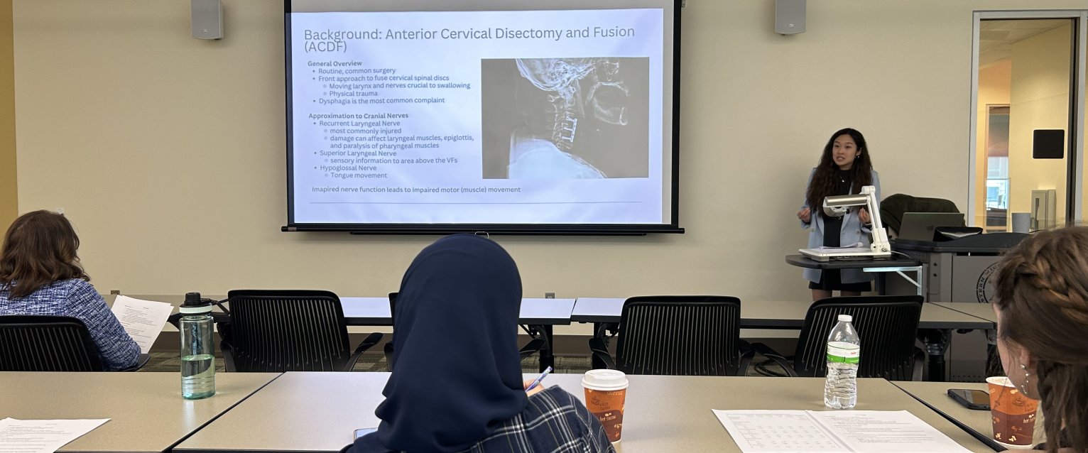 An honors student defends her thesis in an honors college classroom.