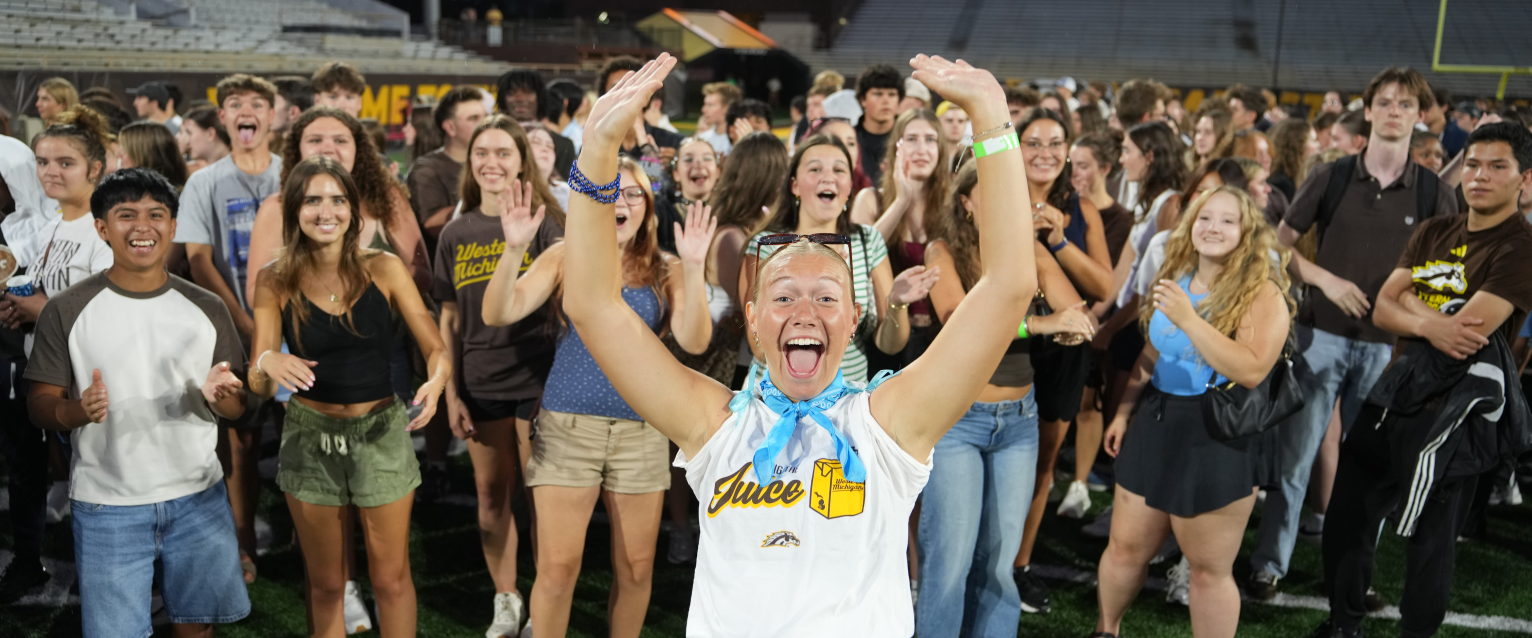 A group of students cheers for a photo in Waldo Stadium.