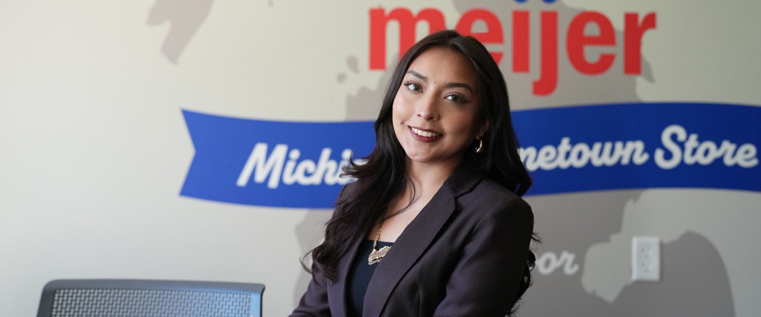 Student standing by the Meijer wall in the Food Marketing Hub