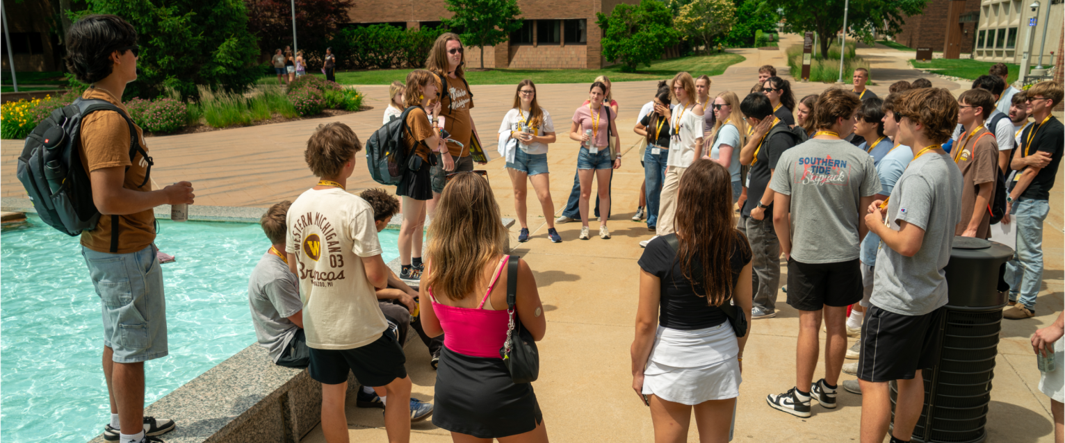 An Orientation Leader talking to his tour group at Miller Fountain