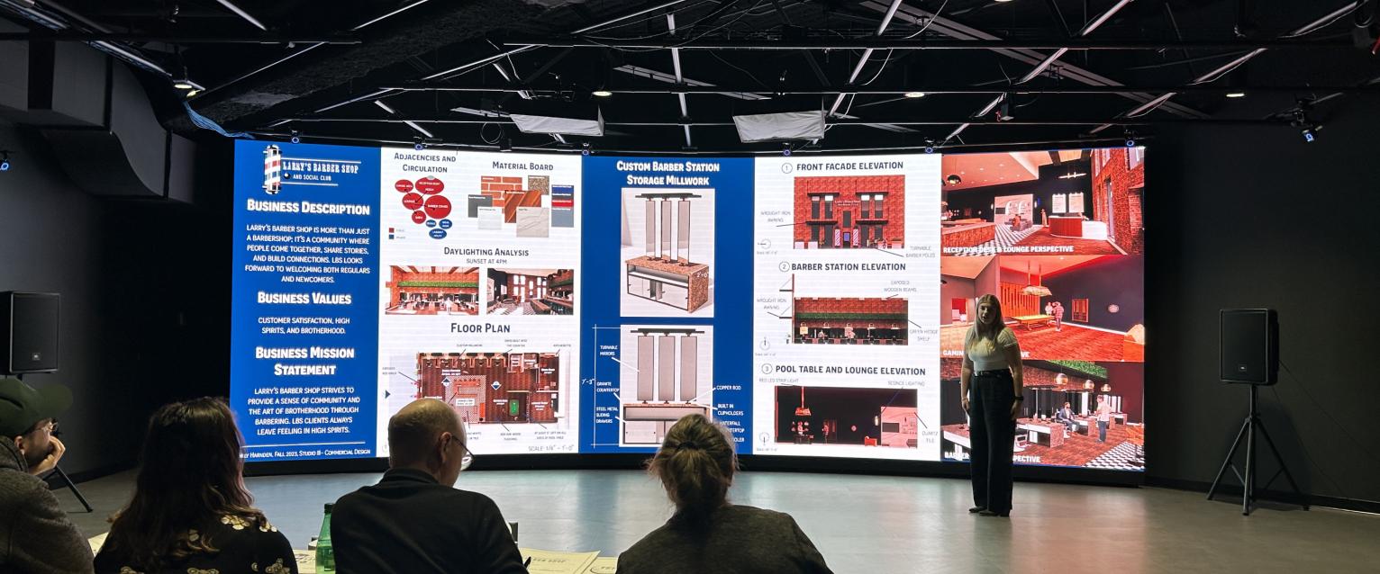 Interior Design student presenting work on the LED wall.