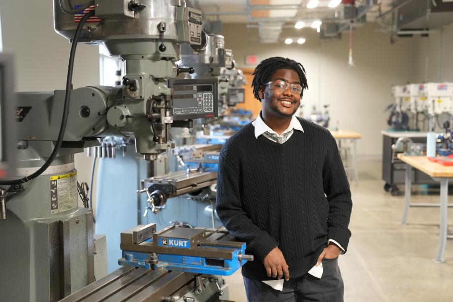 Jonathan Malone stands next to a machine in a lab.
