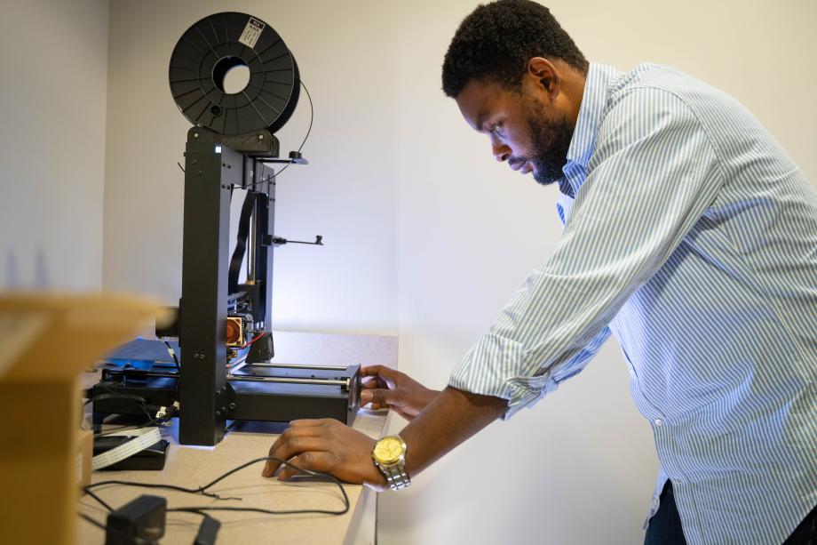 Dan Praise works on a 3D printer.