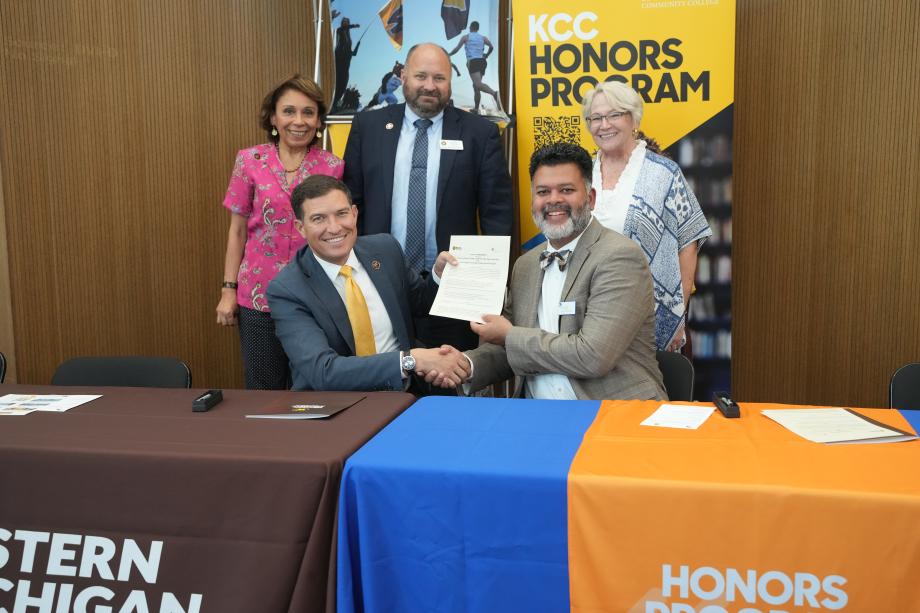 President Kavalhuna and Kellogg Community College's president shake hands at a table.