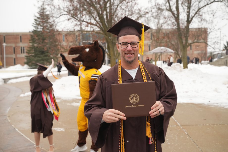A.J. Tate poses outside with his diploma.