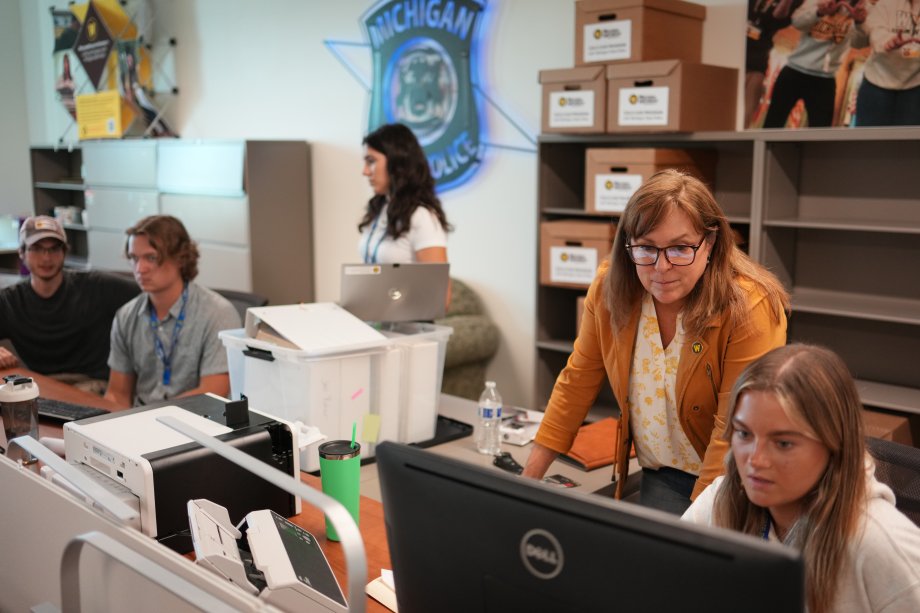 Dr. Ashlyn Kuersten talks with a student at a computer in the Cold Case Program lab.