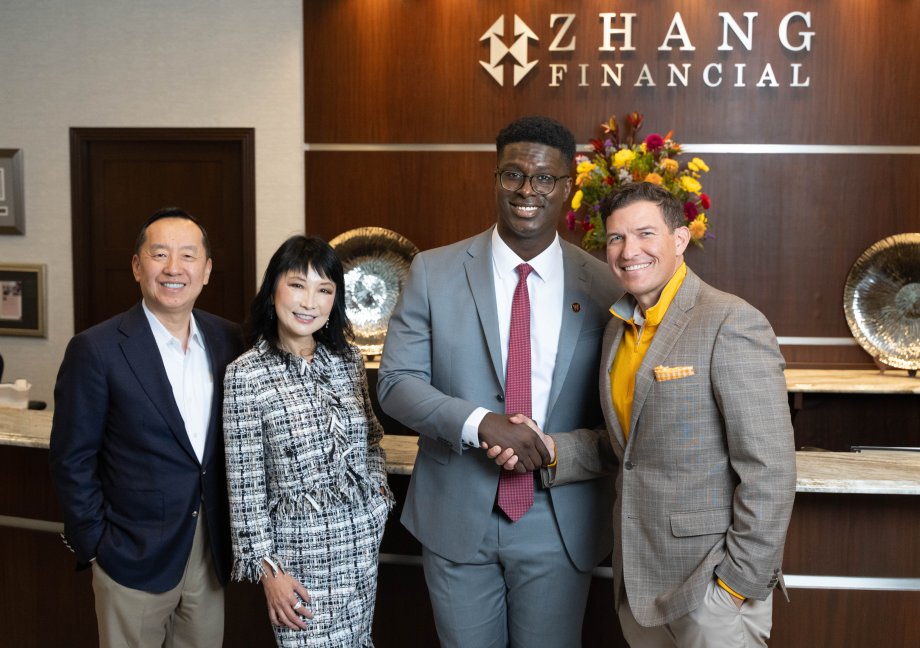 Charles Zhang, Lynn Chen-Zhang, Mo Tall and President Russ Kavalhuna stand in the lobby of Zhang Financial.