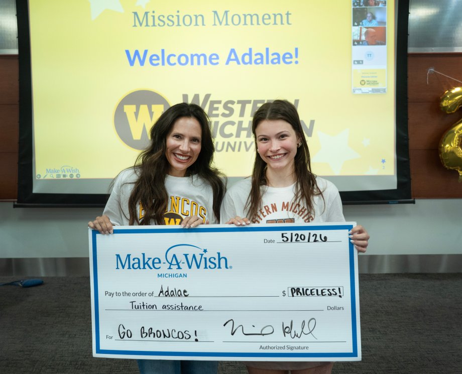 Grand Rapids high school student Adalae and her mom hold a large check from Make-A-Wish.
