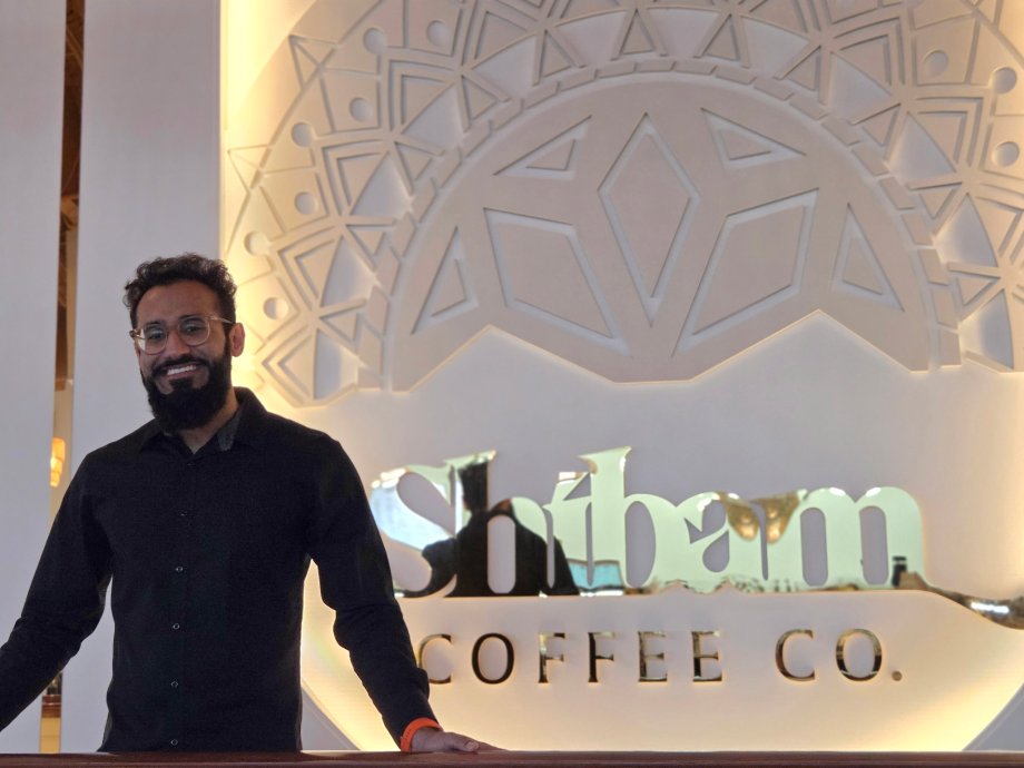 Talal Arshad, Western Michigan University alumnus and local business owner, smiles for a portrait in Shibam Coffee Co., the Yemeni coffee shop he established in Kalamazoo