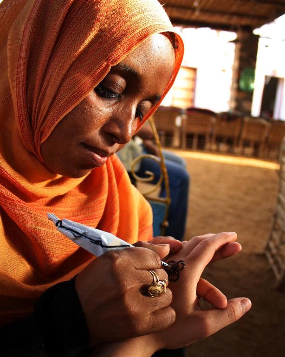 Egyptian woman paints Henna tattoo.