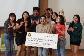 Moises holding scholarship check