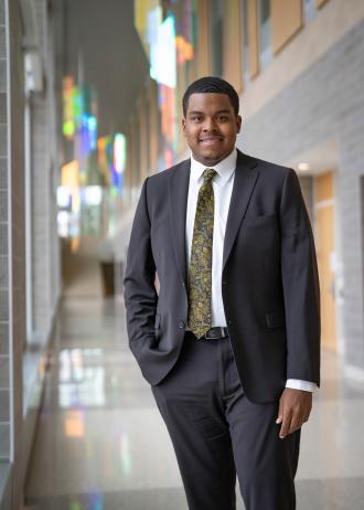 Asa Hollingsworth poses for a photo in a suit.