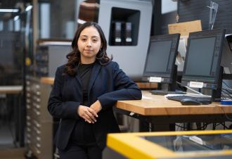 Liset Diaz-Cortes leans on a desk.