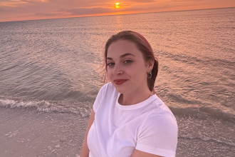 Alayna Sutherland in front of a sunset on the beach