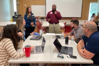 A group of attendees working together at a table during the New Faculty Orientation.