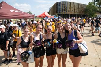 A group of students pose for a picture with popcorn buckets.