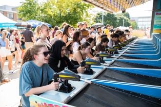 Students play a carnival water game.