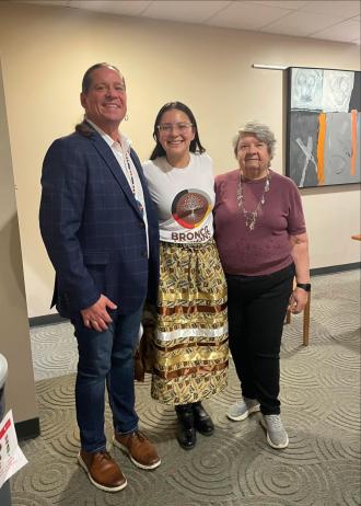 Three people stand together for a picture.