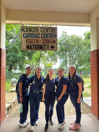 5 PA students in front of a hospital sign in Kenya