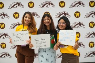 International Student Orientation leaders pose by the photo wall.