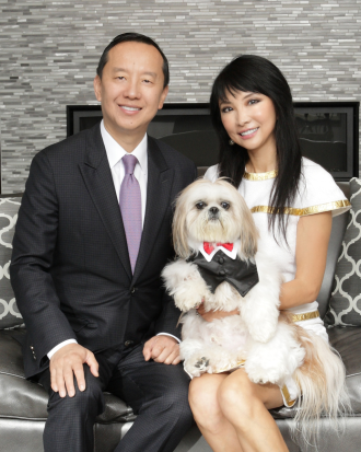 A portrait of Charles Zhang and Lynn Chen-Zhang with their dog.