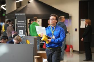 A student walks with a laptop.