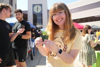 Alex Kasprzyk holds a plant.
