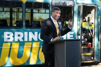 President Russ Kavalhuna stands at a podium.